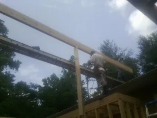 Carpenter setting a ridge beam over a new addition frame — Ice Dam Removal by Roofing Brothers in Schaumburg