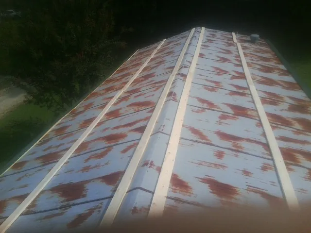 Rusted metal roof panels with new wood purlins before replacement — Storm Damage Roof Repair in Schaumburg by Roofing Brothers