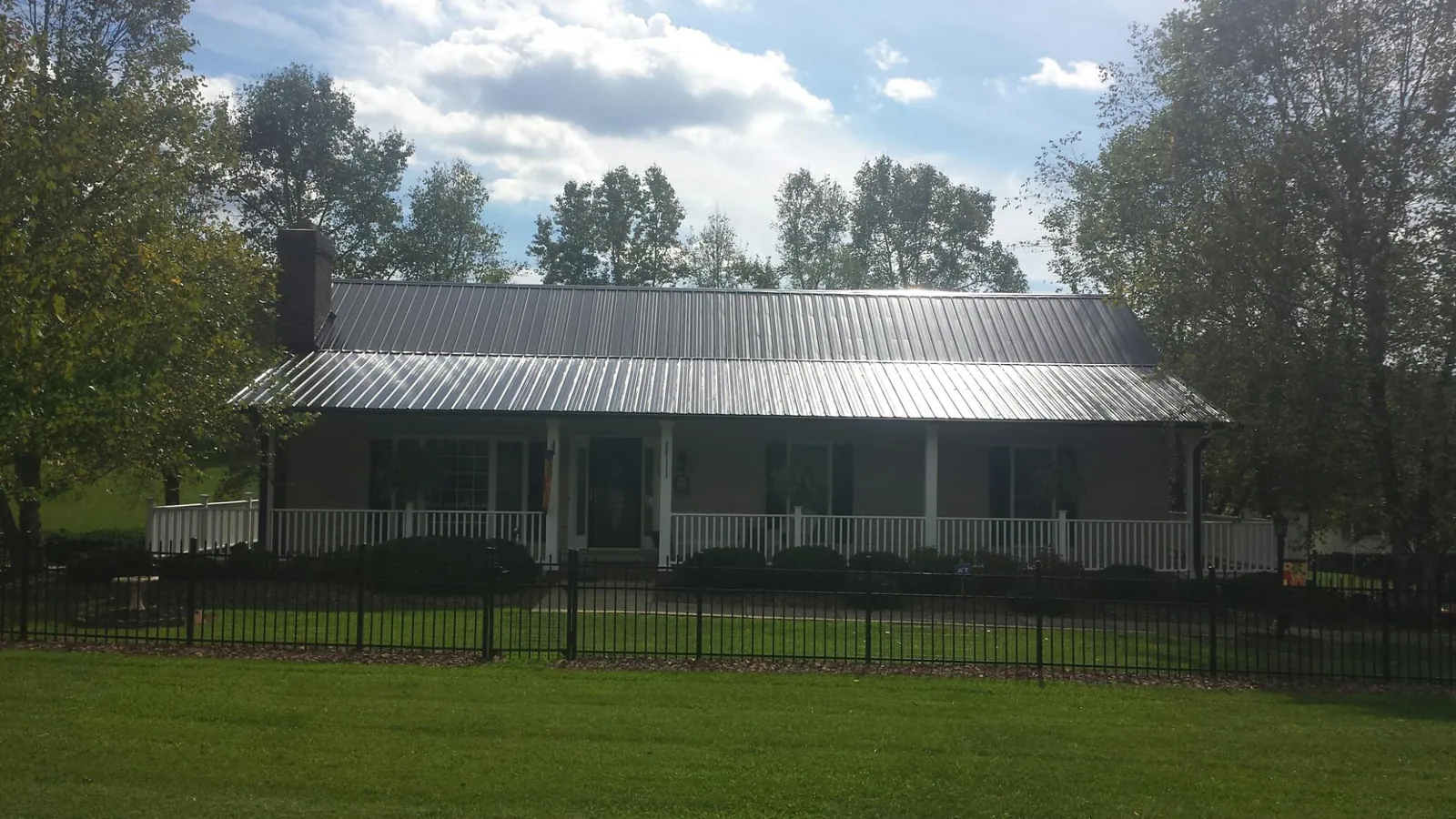 Gray metal roof on a brick ranch with a full width front porch — Gutter Guard Installation work by our crew in Schaumburg